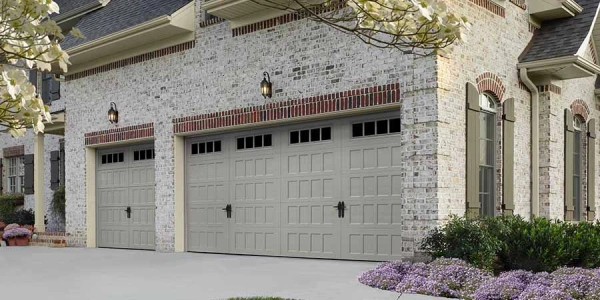 Premium gray garage doors on brick suburban home