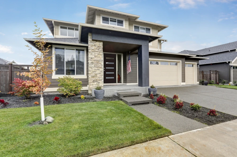 Modern luxury home exterior with smooth siding and stone accents