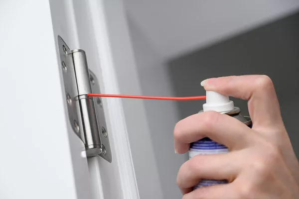 a man cleaning and degreasing his door hinges