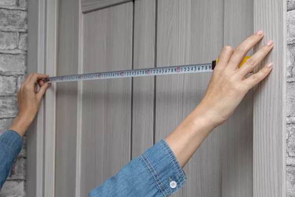 a woman measuring for a new storm door