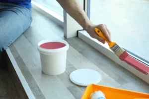 man painting window frame red